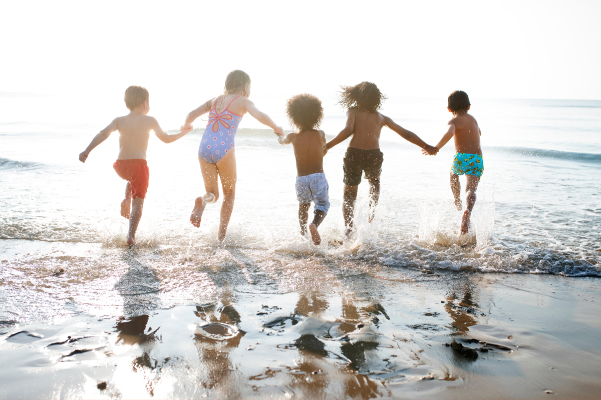 Diverse group of kids running at the beach